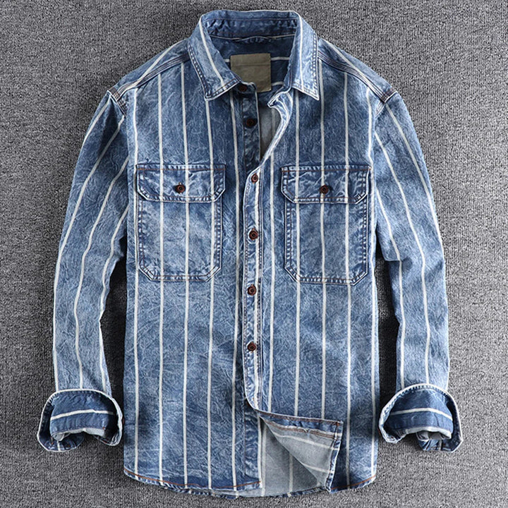 Närbild av en randig jeansskjorta för män, visar tygets struktur och moderna avslappnade snitt.