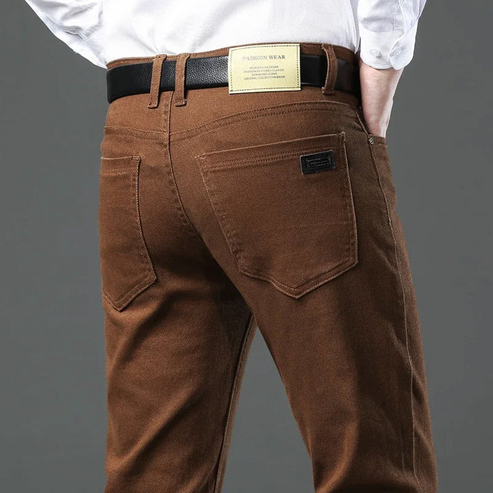Närbild linning & knapp på herrbyxor casual. Stilren design med praktiska detaljer för modern look.