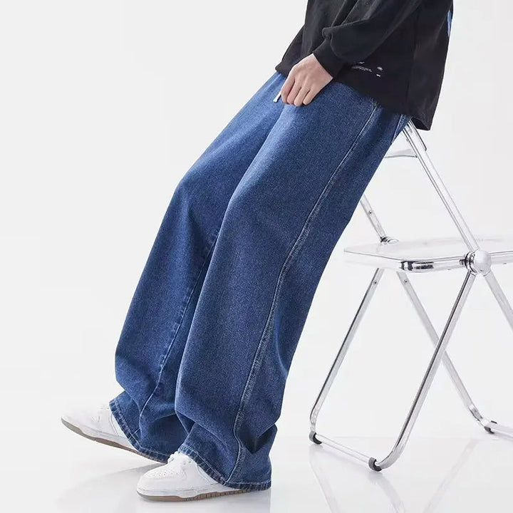 Bakifrån: Blå herrjeans med vida ben, lösa och bekväma. Perfekta vårjeans med modern, avslappnad passform.