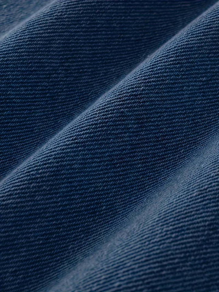 Textur på stretchig denim av trasiga herrjeans, visar kvalitet och design