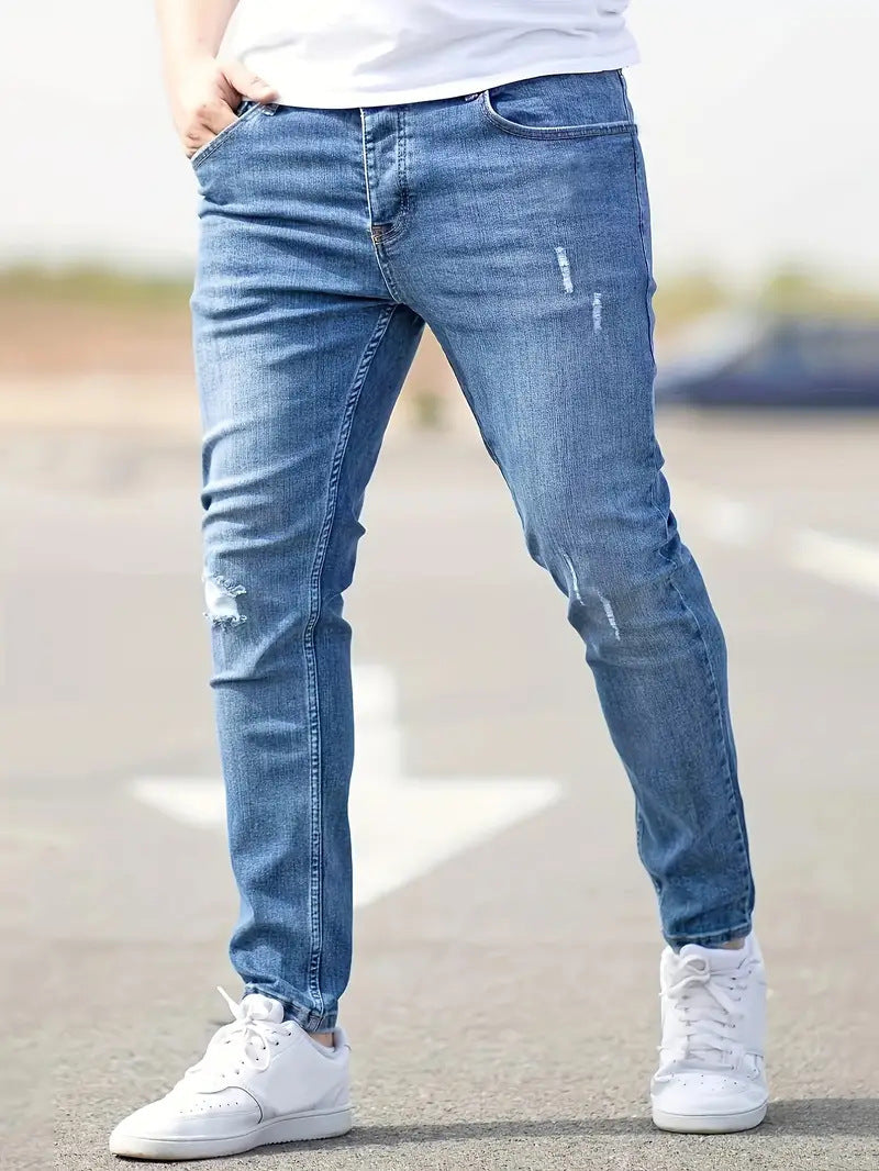 Grå herrjeans, stretchiga och trasiga för en modern casual look. Syns bakficka