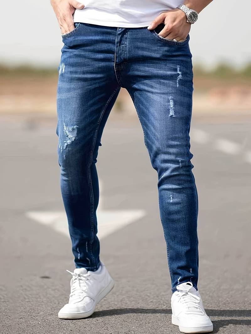 Moderna herrjeans, stretchiga med strategiska trasiga detaljer i mörkblå denim