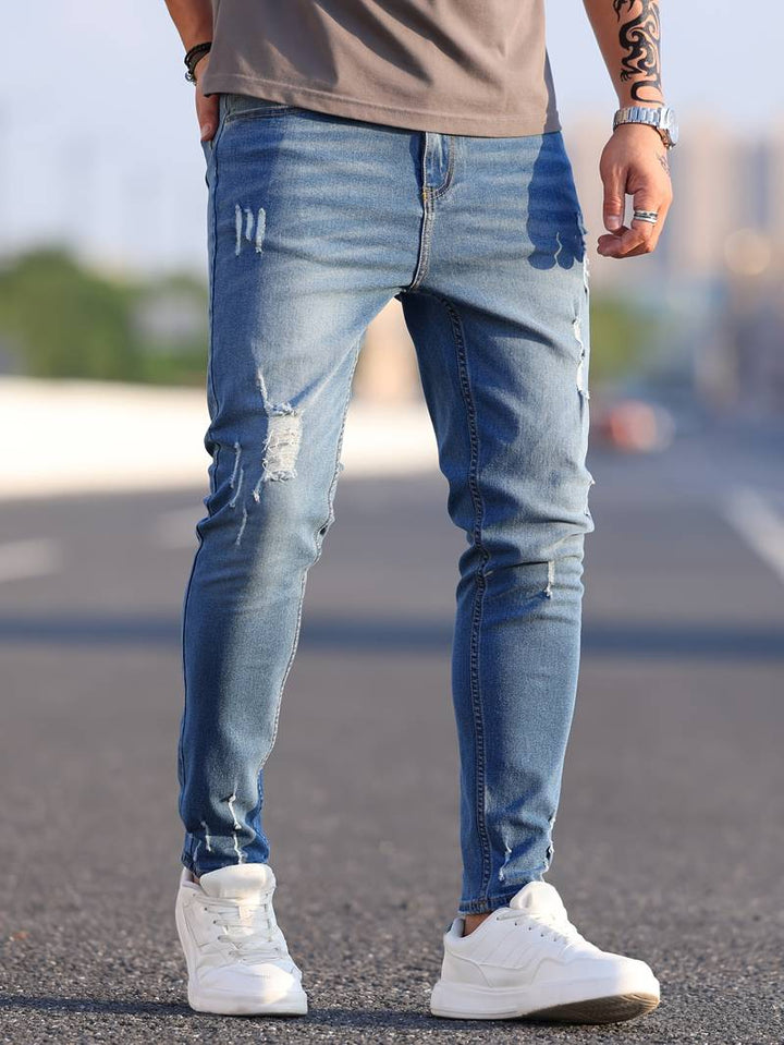 Detaljbild av trasiga knän på stretchiga herrjeans i modern och casual stil
