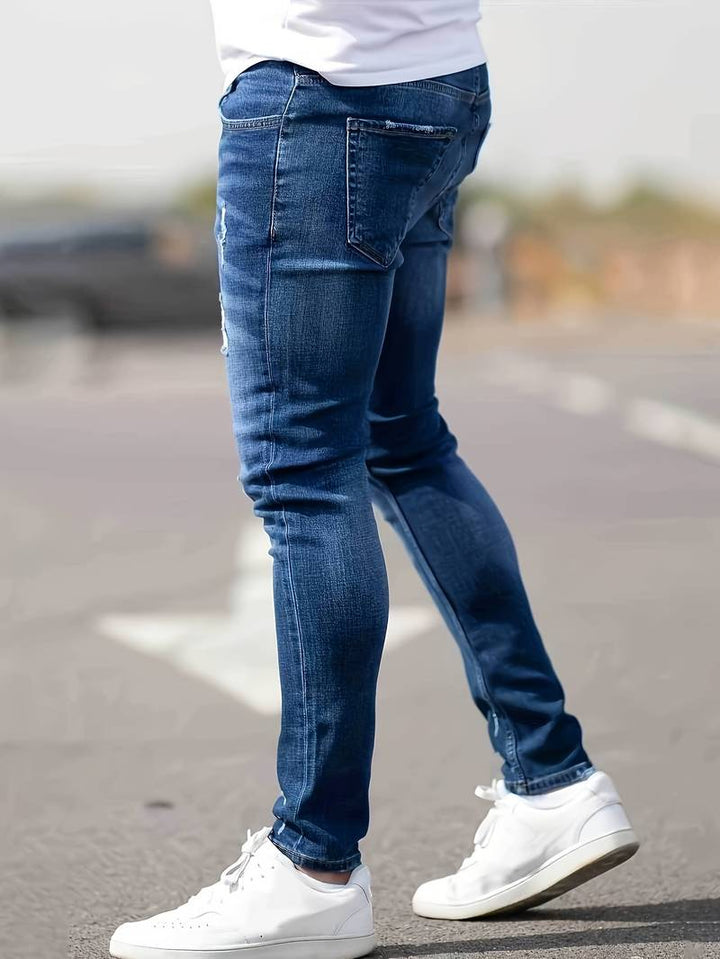 Helkroppsbild av man som bär moderna trasiga stretchjeans, bra passform