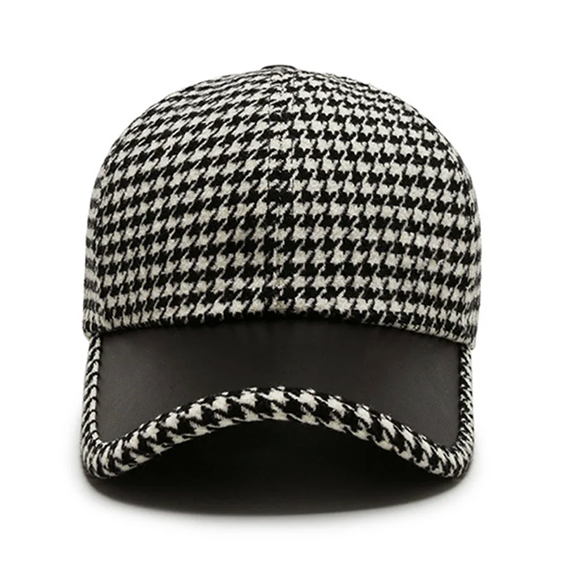 Stilren herrkeps i klassiskt houndstooth med eleganta konstläderdetaljer. Passar både modern & klassisk stil.