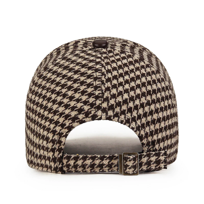 Klassisk herrkeps i houndstooth-mönster, förhöjd med diskreta konstläderdetaljer. En mångsidig keps.