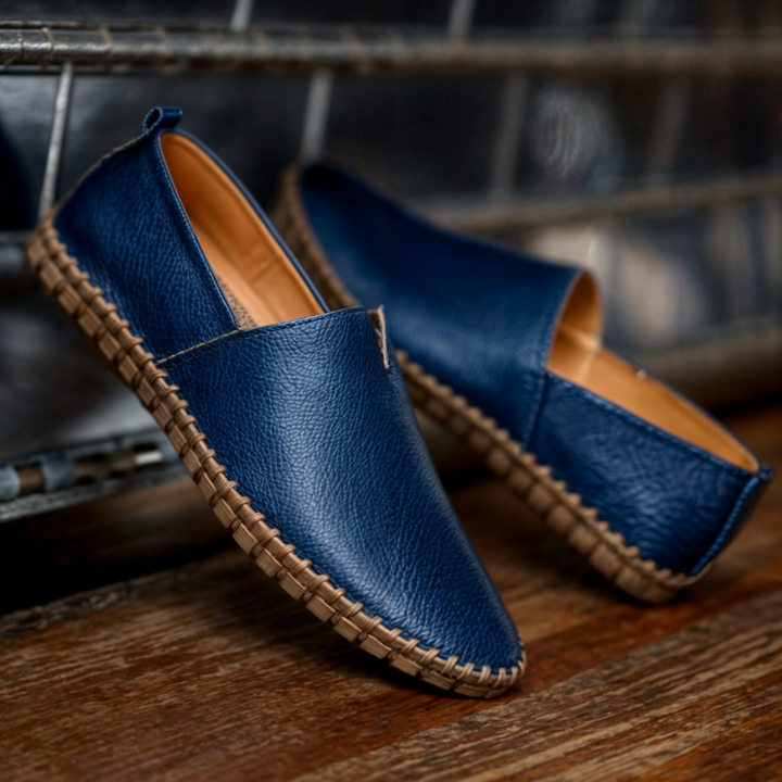 Modell med fötterna i svarta syntetiska läderloafers, visar hur de ser ut på