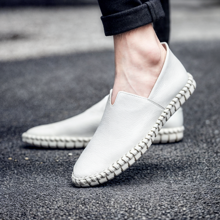 Ensam herrloafer i beige syntetiskt läder, fotograferad från sidan med fokus på detaljer