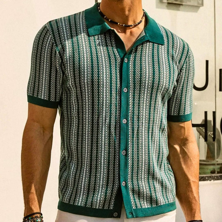 Man bär modern herrpolo i andningsbart tyg med chevrondetaljer, perfekt för lediga tillfällen.
