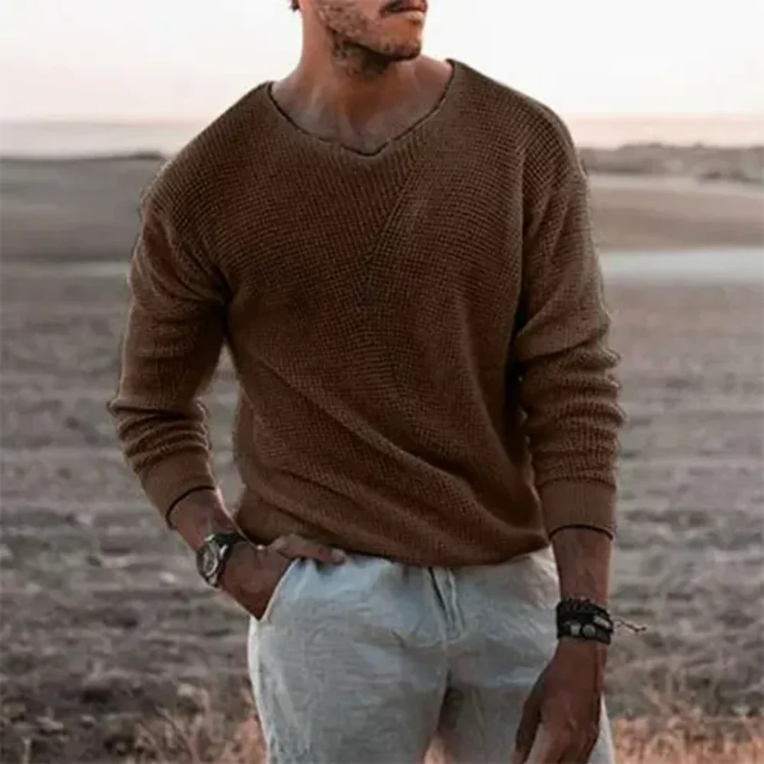 Detaljbild av stickad herrpullover med lång ärm. Ger en elegant och bekväm känsla för herrkläder.