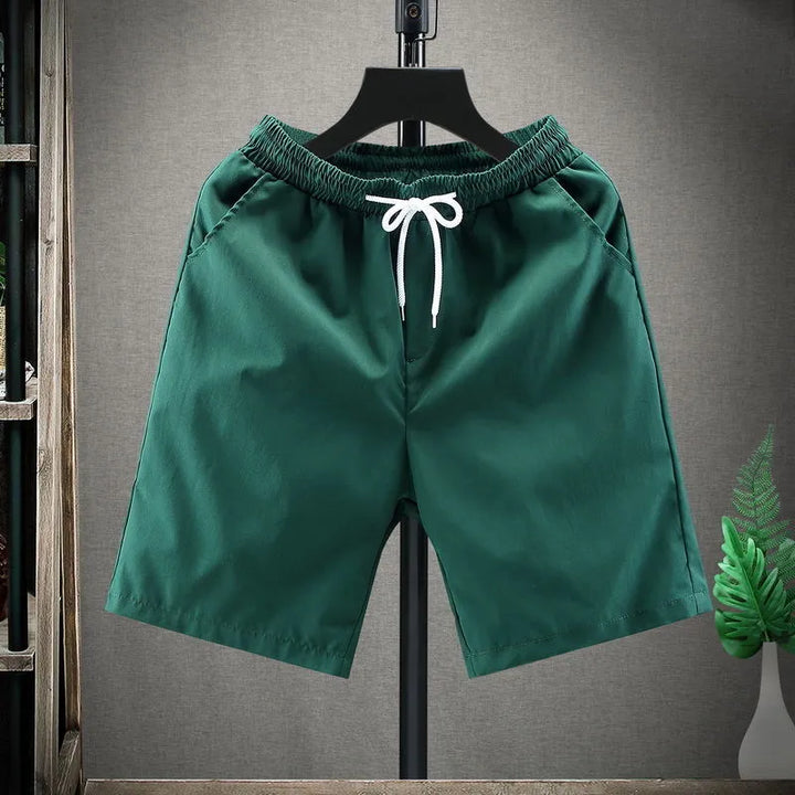 Modell bär avslappnade herrshorts med snörning, rör sig fritt, idealiska för sommaraktiviteter.