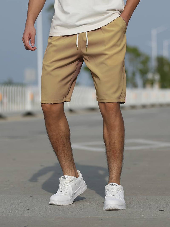 Framsida av avslappnade herrshorts med snörning och rymliga fickor, perfekt för fritid och bekvämlighet.