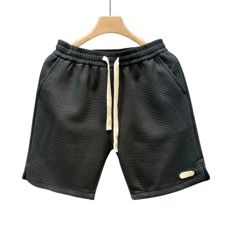 Avslappnade träningsshorts för herrar med unikt vågmönster. Perfekta för sport, strand och bekväm stil.