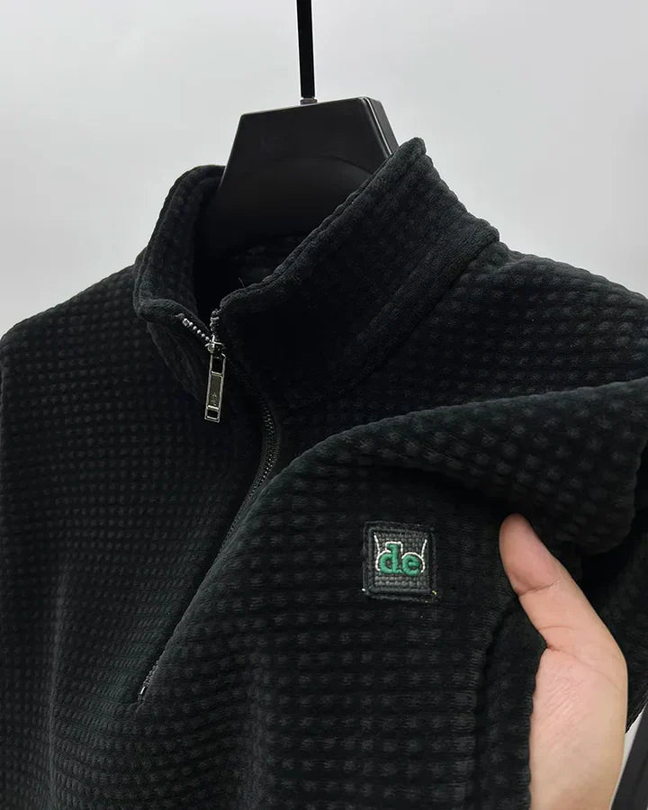 Detaljbild av herrtröjans moderna halvzip-krage. Komfortabel stickning med elegant touch.