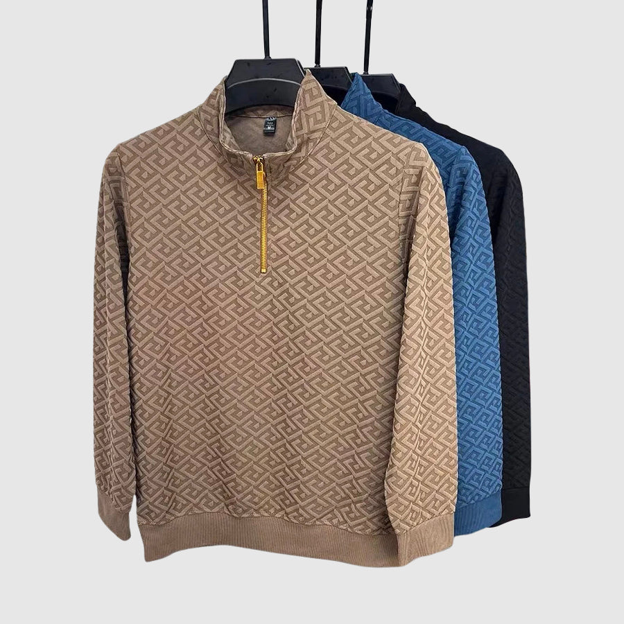 Detaljbild av en geometriskt mönstrad herrtröja med elegant mockhals. Långärmad för snygg höststil.