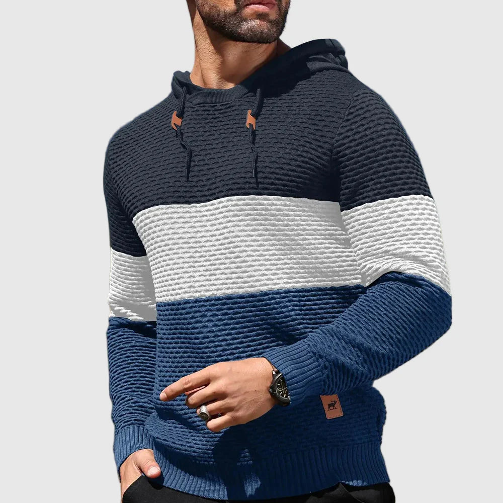Man bär trendig trefärgad herrtröja med justerbar huva. Bekväm stickad vintertröja, casual stil.