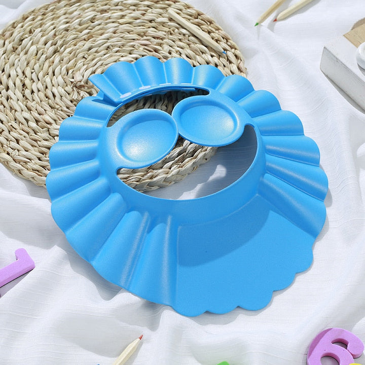Babyduschmössa i blått med öronskydd, designad för att göra barnbad bekvämt och roligt.