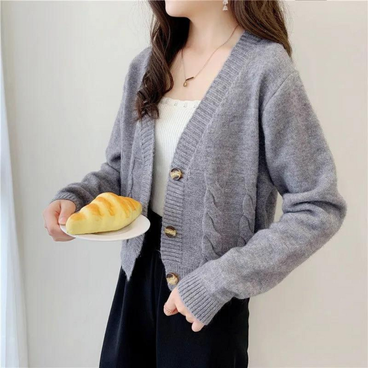 Elegant kabelstickad damcardigan med V-ringning, idealisk för höstmode och vinterkläder.