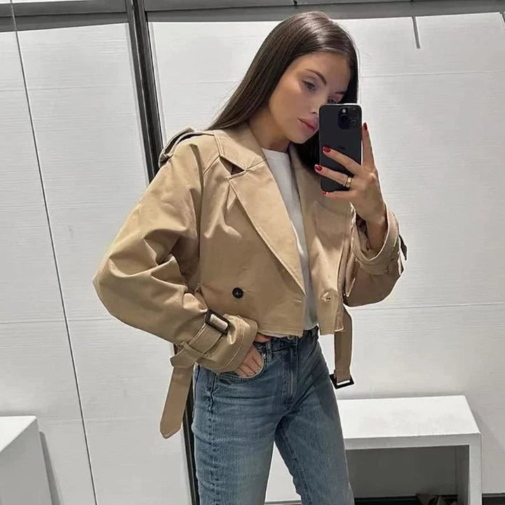 Baksida av elegant damtrenchcoat; tidlös kappa i klassisk stil med sprund, idealisk för stilmedvetna kvinnor.