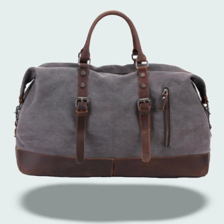 Robust canvas duffelväska med eleganta läderdetaljer, idealisk som weekendväska för herr.