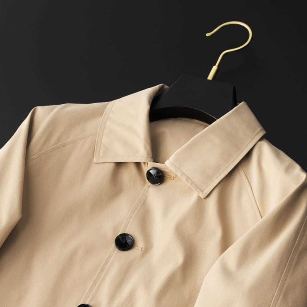 Modern klassisk kort damtrenchcoat med spridd krage och snygga detaljer. Ett måste för vårens mode.