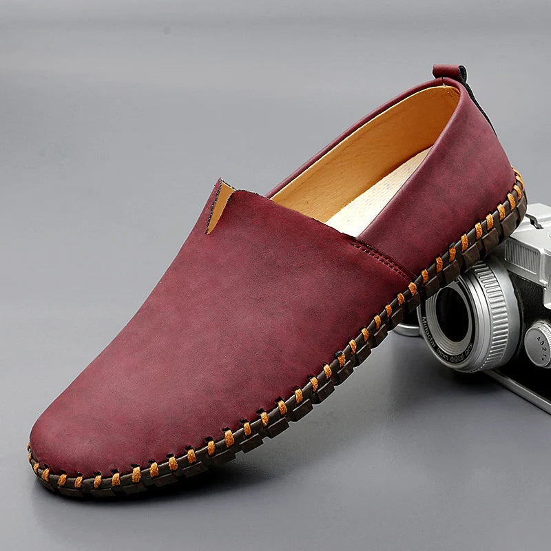 Sidovy av eleganta herrloafers i läder, klassisk slip-on design. Idealisk för smart casual.