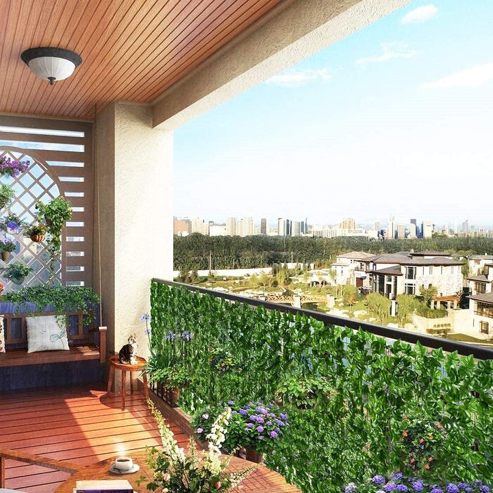 Grönt insynsskydd med falska löv, skapar en lummig och privat atmosfär i trädgården