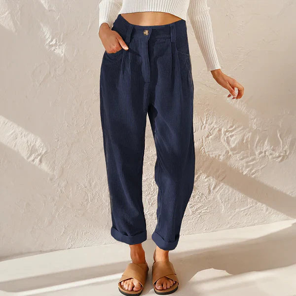 Kvinnlig modell poserar i casual byxor med avslappnad passform och resårmidja, kompletterad med en stilren topp. Höstens mode, vardagsbyxor.