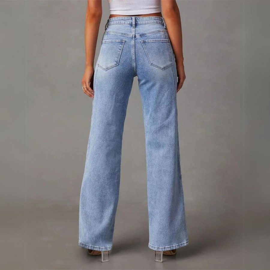 Sida vy av damjeans i denim, vidbenta och med hög midja, framhäver modern vardagsstil.