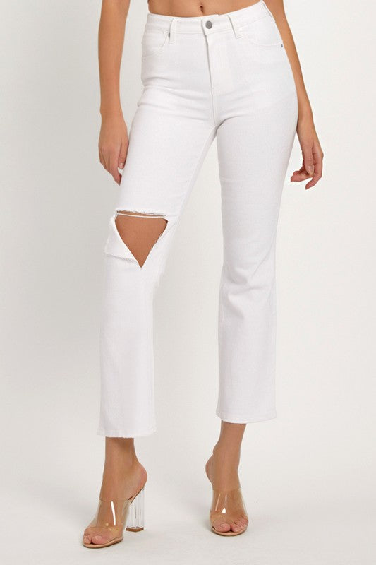 Närbild av textur på vita distresserade kvinnors denimjeans med trendiga detaljer för fritid.