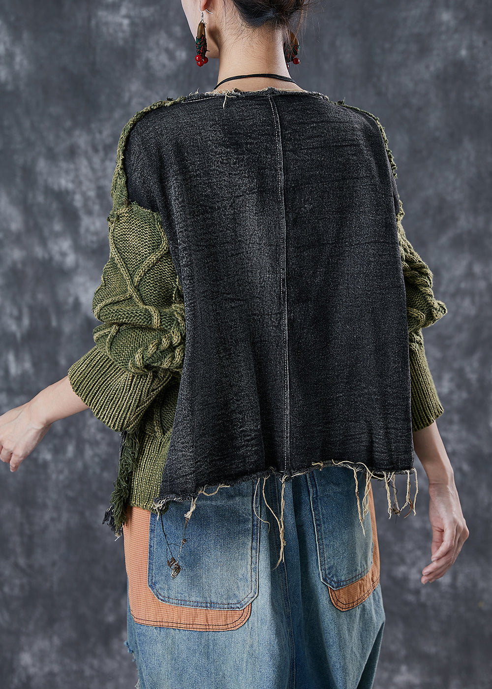 Modern asymmetrisk damtröja med unika rippade detaljer och patchwork, perfekt för stilmedvetna kvinnor.