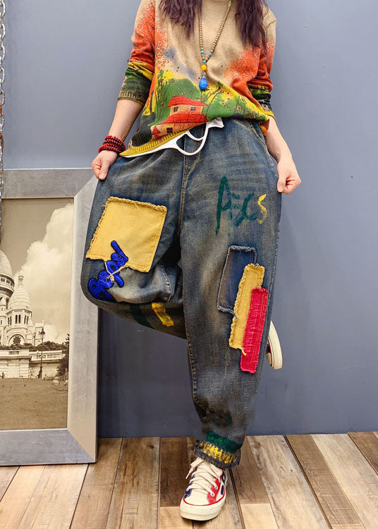 Detaljbild på patch-applikationer på kvinnors avslappnade denimbyxor, unik design.