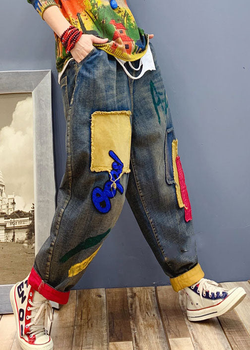 Modell bär bekväma kvinnors denimbyxor med patchar, trendigt vårmode.
