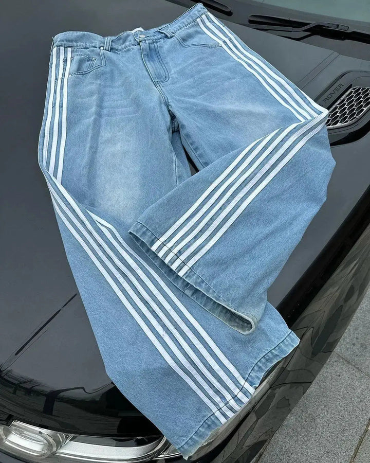 Detaljbild av Y2K baggy jeans: hög midja, avslappnad passform och sidränder i blått tyg