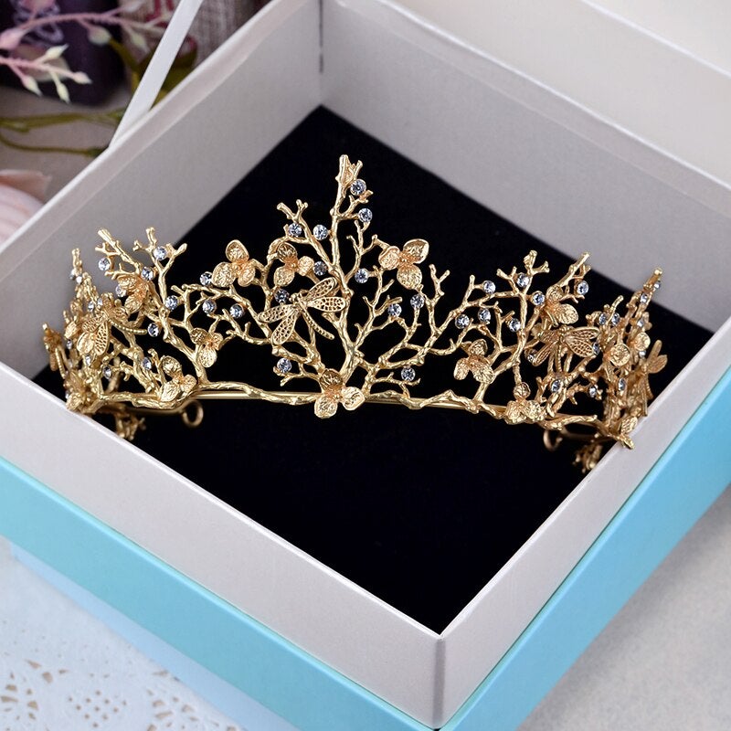 Detaljerad bild av kvinnors festkrona, en barock guld libell tiara med glittrande stenar