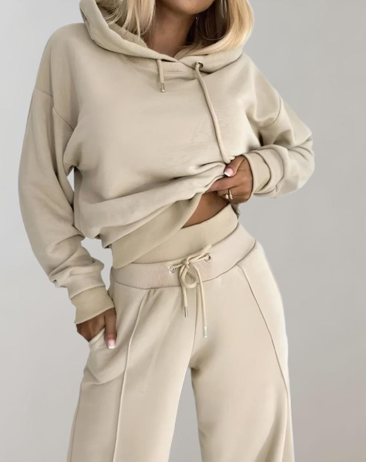 Streetwear-inspirerad kvinnors träningsoverall med luvtröja & byxor. Casual och sportig look.
