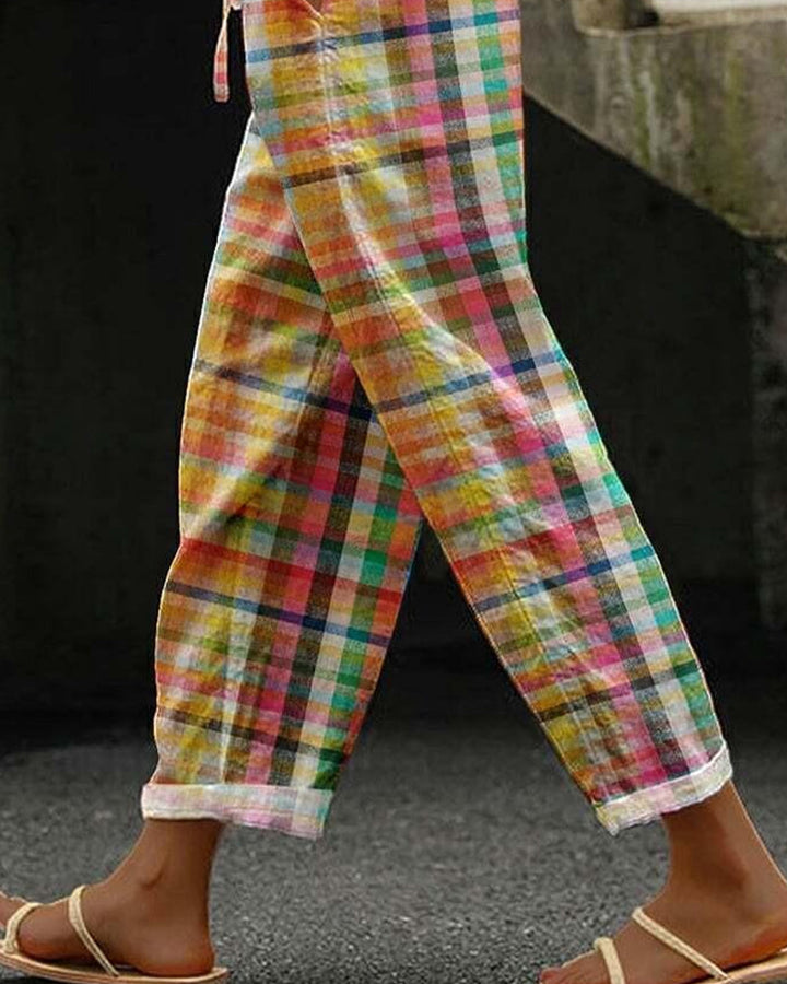 Modell bär gula rutiga dambyxor med medelhög midja, mjukt material, i en klassisk och bekväm stil.
