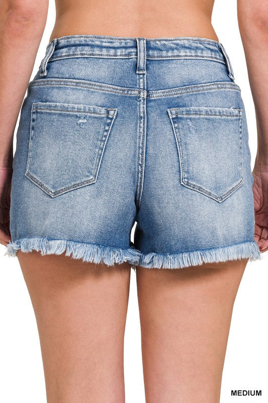 Somriga damshorts i denim med medelhög midja och snygg rå fransad kant, idealiska för strand och fritid.