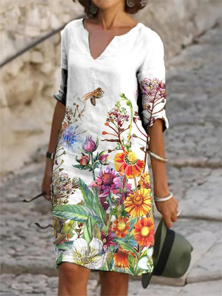Kvinnlig midi klänning med vackert blommigt mönster, en elegant del av sommargarderoben.
