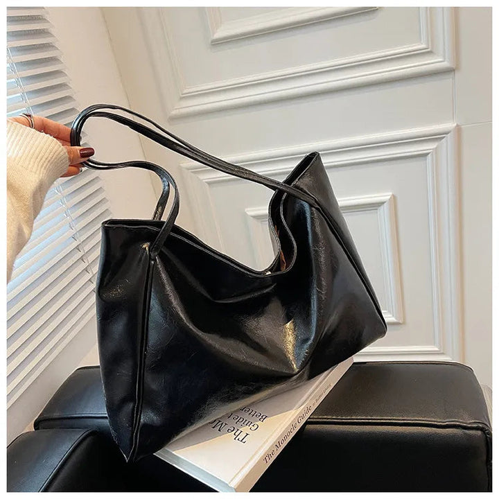 Tidlös bucketväska för kvinnor. Elegant axelväska, mångsidig handväska med retro-inspirerad design.