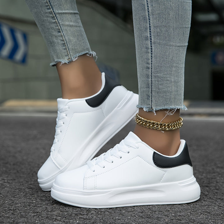 Moderna svartvita damsneakers med ergonomisk passform. Komfortskor för stilmedvetna promenader.