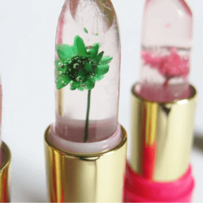 Sminkbild: Kvinna applicerar färgskiftande läppstift med geléblomma för mjuk, återfuktande läppvård.