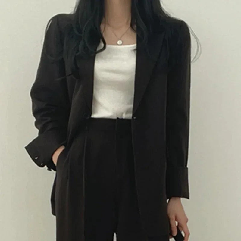 Stilren kvinnors kostym. Modern kavaj och högmidjade byxor för en polerad och elegant outfit.