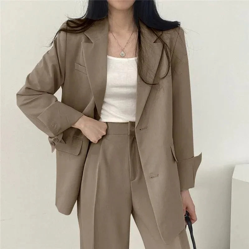 Modern kvinnors kostym med bekväm kavaj och byxor med hög midja. Perfekt för en chic och mångsidig look.