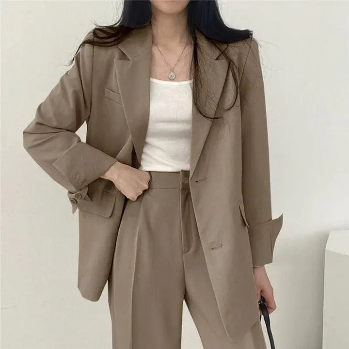 Modern kvinnors kostym med bekväm kavaj och byxor med hög midja. Perfekt för en chic och mångsidig look.