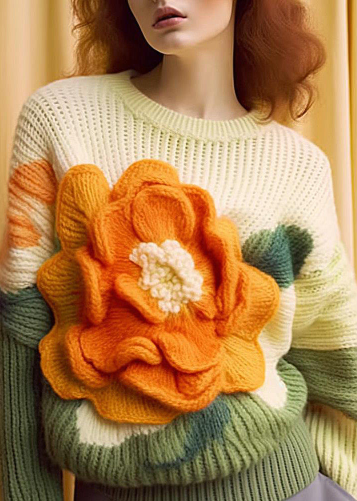 Detaljbild av en avslappnad kvinnors långärmad topp med livfullt blommönster och klassisk o-hals design.
