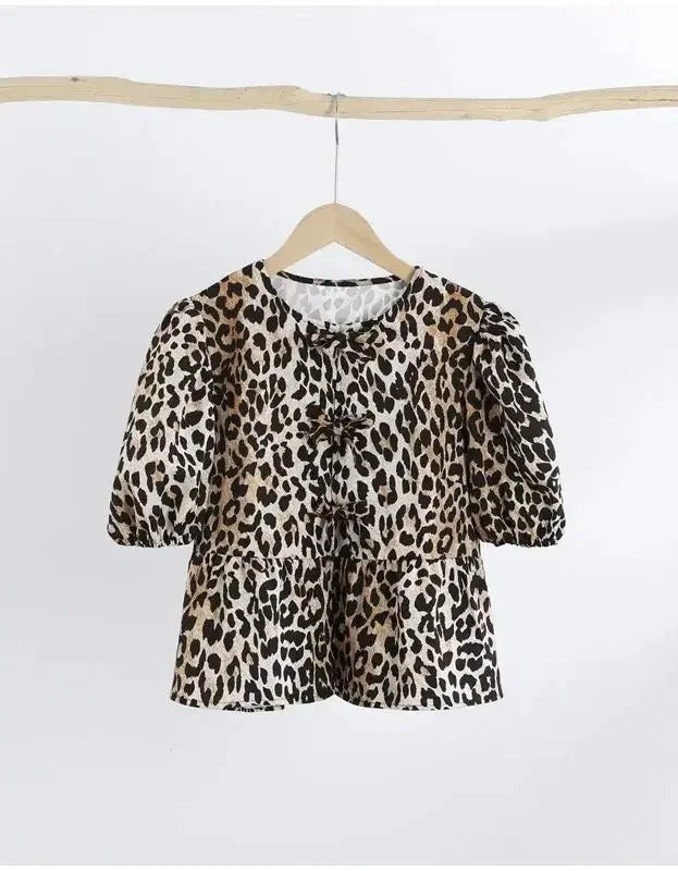 Detaljbild på puffärmen på en kvinnors leopardblus. Trendig och elegant design för vardag och fest.