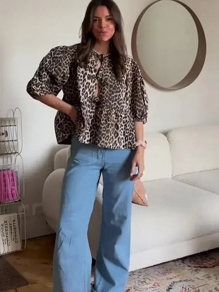 Närbild av det trendiga leopardmönstret på kvinnors blus. Mjukt tyg, chic design med puffärm.