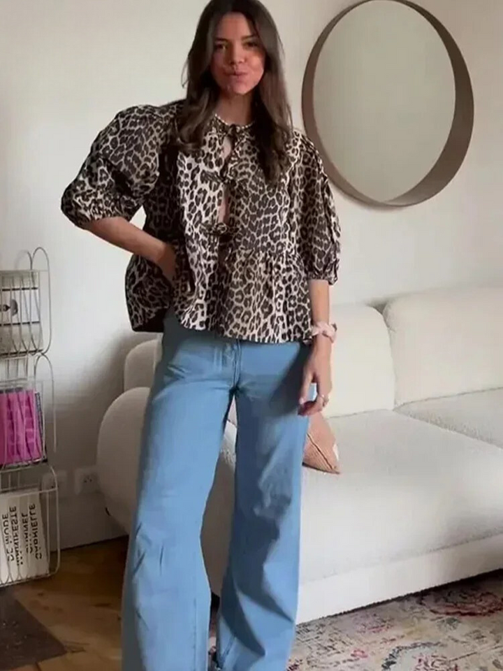 Närbild av det trendiga leopardmönstret på kvinnors blus. Mjukt tyg, chic design med puffärm.