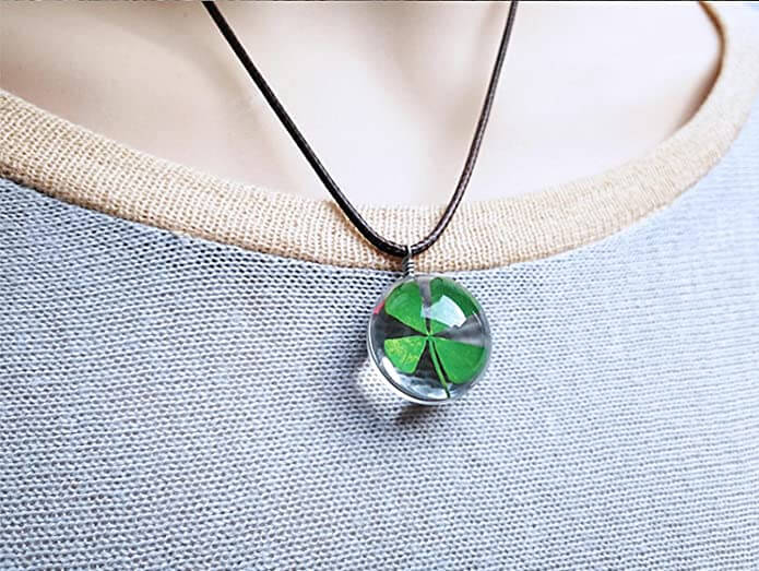 Damhalsband med fyrklöver i harts presenteras. Lyckoamulett och stilfull gåva för kvinnor.